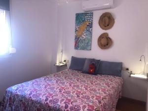 马拉加Aunt Antonia Beach House的一间卧室配有一张带紫色毯子的床