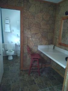马吉谷Stony Creek Motel的一间带卫生间和红色凳子的浴室