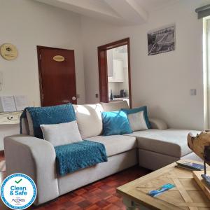 大里贝拉Margarida House - Stone Apartment的客厅配有白色沙发和蓝色枕头。