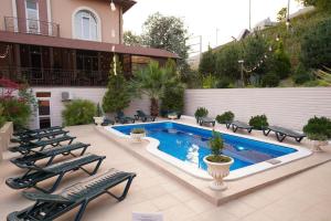 阿德勒帕帕亚酒店的一个带游泳池和椅子的庭院和一座建筑
