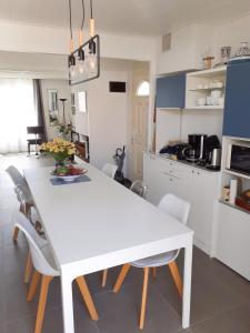 莱萨布勒-多洛讷Les portes du soleil的厨房里设有白色的餐桌和椅子