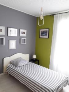 莱萨布勒-多洛讷Les portes du soleil的一间卧室设有一张床和绿色的墙壁