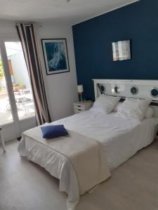 莱萨布勒-多洛讷Les portes du soleil的一间卧室配有一张白色大床和蓝色的墙壁