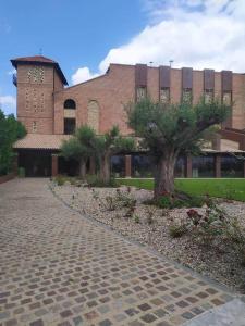 阿尔贝尔达德里瓜Hotel Vinícola Real-200 Monges的前面有两棵树的砖砌建筑