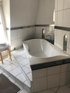 海德堡Best Location - Luxury Loft Riverview的白色瓷砖浴室内的白色浴缸