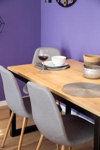 里耶卡Apartments tRIo的一张带椅子的木桌和一杯葡萄酒
