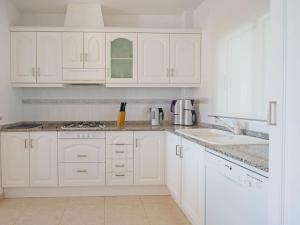 BenijófarBelvilla by OYO Casa Morena的白色的厨房配有白色橱柜和水槽