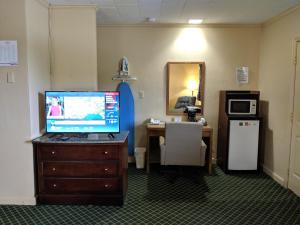 Glennville格伦维尔奇瑞奥酒店的一间设有书桌和梳妆台电视的房间