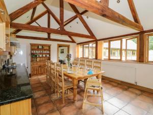 CastlemortonBeesoni Lodge的厨房以及带木桌和椅子的用餐室。