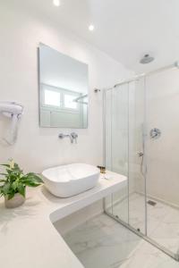 提诺斯Nama Boutique Hotel的白色的浴室设有水槽和淋浴。