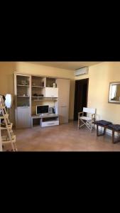 格罗塞托港Marina Apartments的客厅设有带冰箱和桌子的厨房