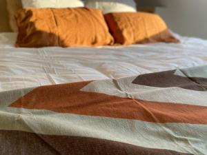 特镇Fenêtre sur Theux的床上有色彩缤纷的毯子和枕头