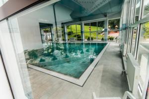 斯派特克维瑟康普克斯贝斯基德酒店的一座室内游泳池,位于一座带窗户的建筑中