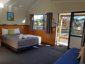 提马鲁TOP 10迪马鲁假日公园酒店的一间卧室设有一张床和一个滑动玻璃门