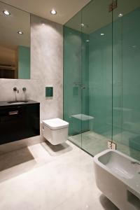 波尔图博阿维斯塔宫殿服务式公寓酒店的一间带玻璃淋浴、卫生间和水槽的浴室