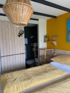 VogelenzangAppartement Bos en Duin的一间卧室设有一张床和黄色的墙壁