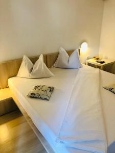 北马马亚-讷沃达里Ido的一张配有白色床单和枕头的大床