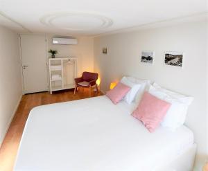 布拉加Anjo33 Flats的卧室配有带粉红色枕头的大型白色床