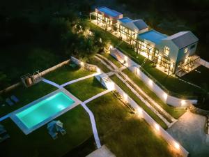 科孚镇Kumquart Guesthouse, 20 people, private pool的享有房子空中景色,晚上设有游泳池