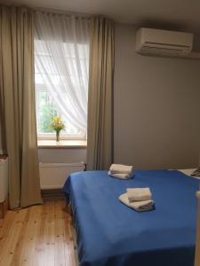 尤尔马拉日落酒店的一间卧室配有蓝色的床和2条毛巾