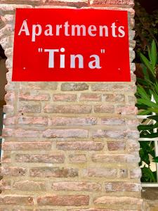 斯巴达Apartments Tina FREE transfer from-to the airport的砖墙上的红色标志