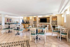 埃尔帕索埃尔帕索西部拉金塔旅馆的一间带桌椅和电视的餐厅