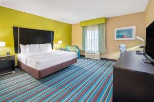 马斯科吉马斯科吉拉金塔套房旅馆的配有一张床和一张书桌的酒店客房
