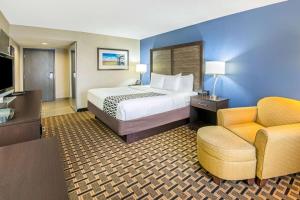 丹尼森德克萨斯湖丹尼森拉金塔套房酒店的配有一张床和一把椅子的酒店客房