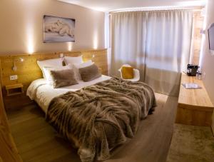 莱德萨阿尔卑斯弗洛孔酒店的一间卧室配有一张带毯子的大床