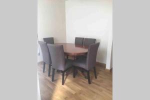 伦敦F3 Cosy Single Room (Sandycroft Guest House)的餐桌、椅子和木地板