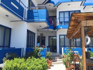 阿彻奇洛斯Anastasia Studios, Apartments & Suites的蓝色的白色房子,设有蓝色的阳台和植物