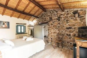 洛特佐拉伊Sa Crai B&B - Sardinian Experience的一间卧室设有两张床和石墙