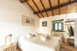 洛特佐拉伊Sa Crai B&B - Sardinian Experience的配有2张床的白色墙壁和木制天花板