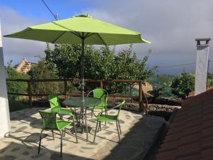 GuarazocaLa Zamora的庭院内一张桌子和椅子,上面有一把绿伞