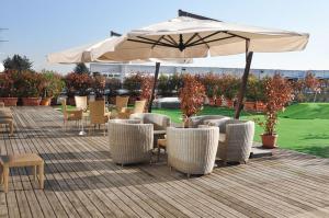 奥佩拉米兰高尔夫酒店的一个带桌椅和遮阳伞的庭院