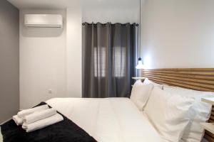 海若克利欧Emfasis Loft Spacious and Elegant Heraklion的一间卧室配有带白色床单和枕头的床。