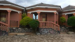 KobokoHotel Delambiance的粉红色的房子,前面有楼梯