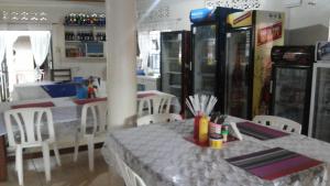 KobokoHotel Delambiance的一间带桌椅和苏打水机的餐厅