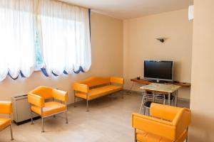 FilottranoHotel Ostello Settecolli Sport的一间配备有橙色椅子和平面电视的等候室