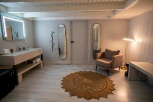 圣胡安Trópica Beach Hotel的浴室设有水槽、椅子和镜子