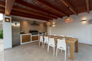 圣若法尔萨克鲁霍尔特皮勒度假屋的厨房配有木桌和白色椅子