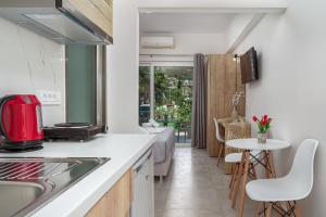 卡拉马孔Antonis apartments的厨房配有水槽和桌椅