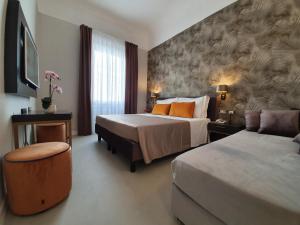 佛罗伦萨Hotel Maxim Axial的酒店客房,设有两张床和一张沙发