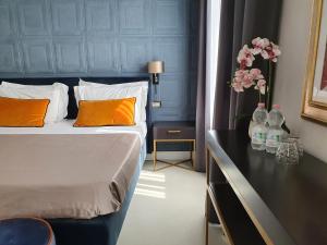 佛罗伦萨Hotel Maxim Axial的一间卧室配有带橙色枕头的床和鲜花桌