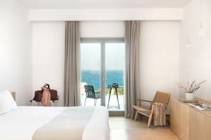 圣斯特凡诺斯Mykonos Soul Luxury Suites的酒店客房设有一张床,享有海景。