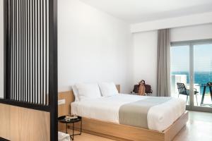 圣斯特凡诺斯Mykonos Soul Luxury Suites的一间卧室设有一张床和一个大窗户