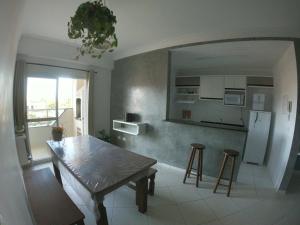 乌巴图巴Beach House Itaguá Apartamento 1 - Em Ubatuba a 300m da orla mais charmosa, com excelente localização的一间厨房,里面配有一张桌子和凳子