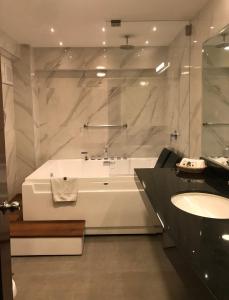 利马雷克萨斯酒店的白色的浴室设有浴缸和水槽。