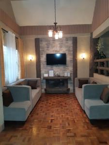 碧瑶Zya 3BR A-House的客厅配有2张沙发和1台平面电视