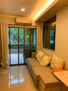 七岩lumpini park beach的带沙发和窗户的客厅